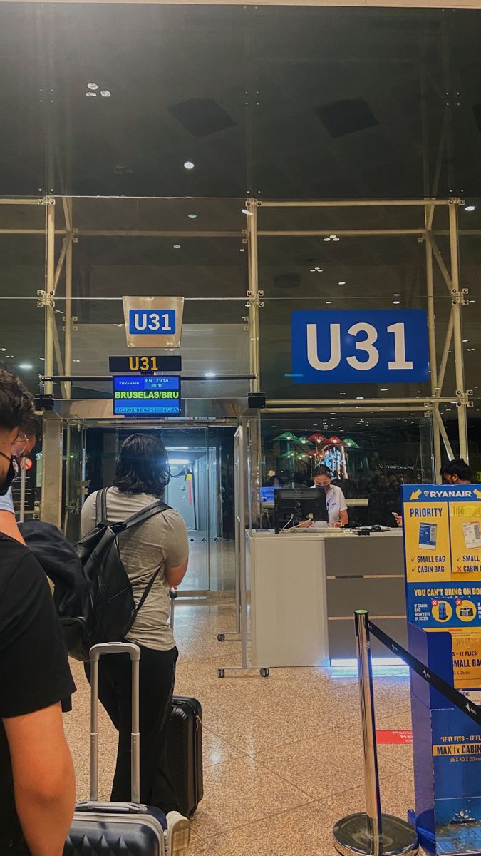 two people standing in an airport with luggage