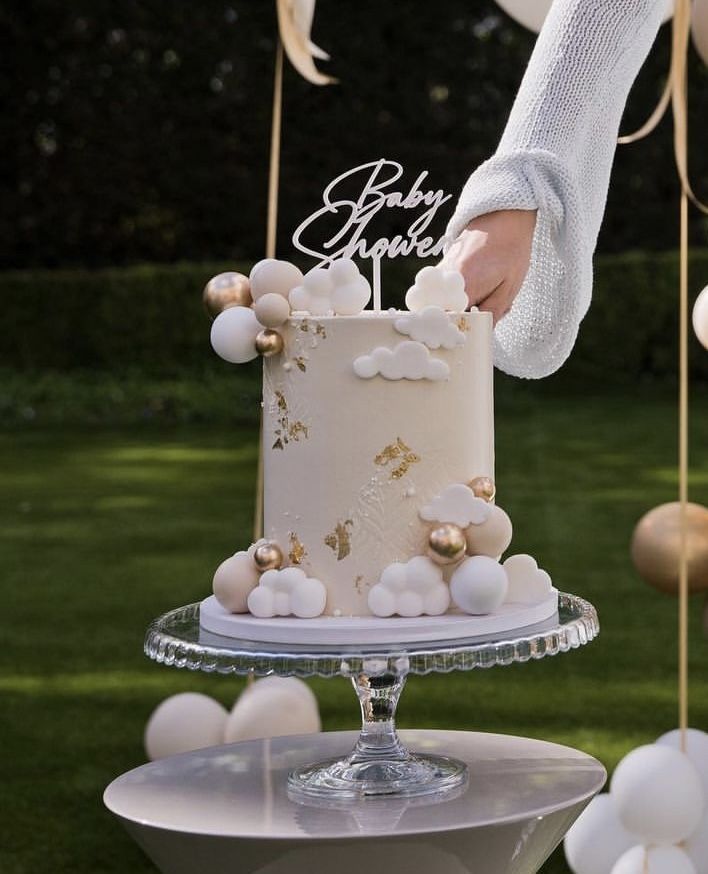 a person holding a cake on top of a table