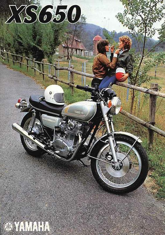 a woman sitting on the back of a motorcycle next to a man standing behind it