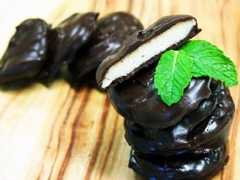 chocolate covered cookies are stacked on top of each other with a green leaf in the middle