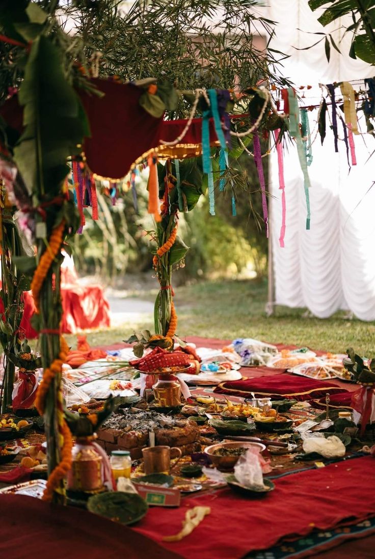 a table covered in food and decorations under a canopy with streamers hanging from it