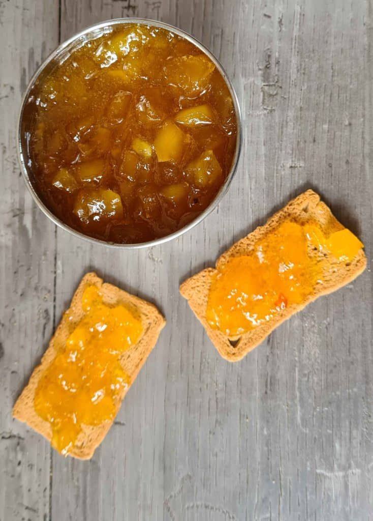 two pieces of bread with jelly on them next to a bowl of jelly