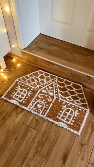 a brown and white door mat sitting on top of a wooden floor next to candles