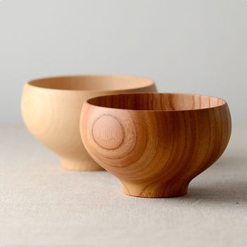 two wooden bowls sitting next to each other