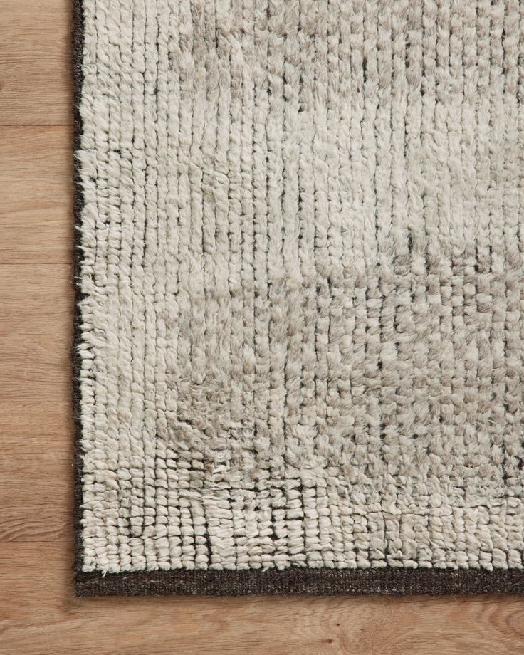 a white and brown rug on top of a wooden floor