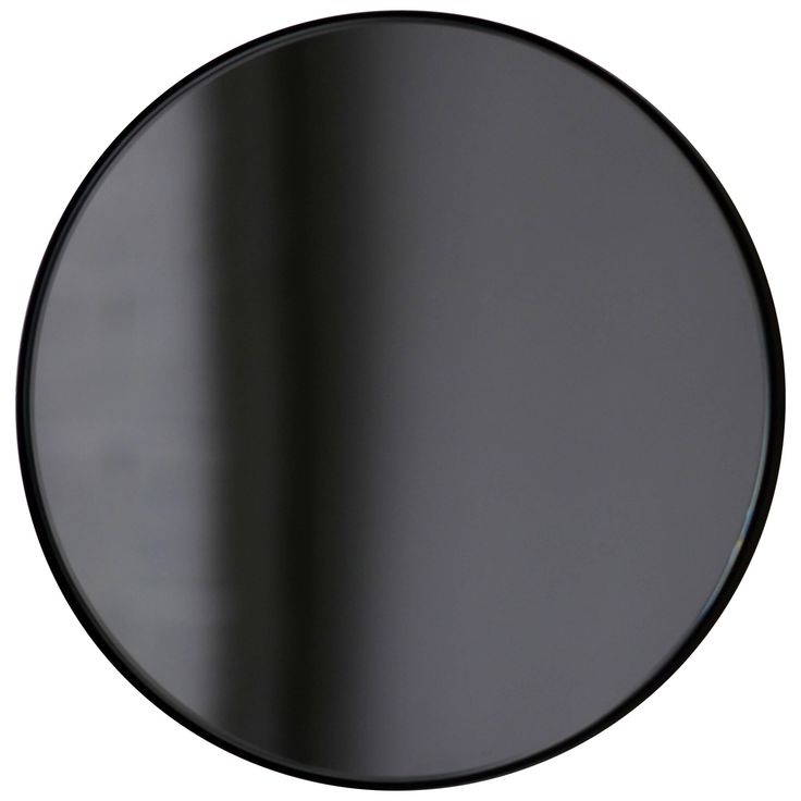 a black round mirror on a white wall