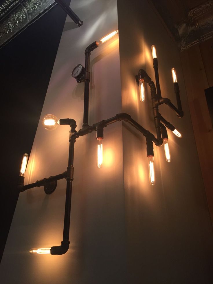 a chandelier made out of pipes and lights