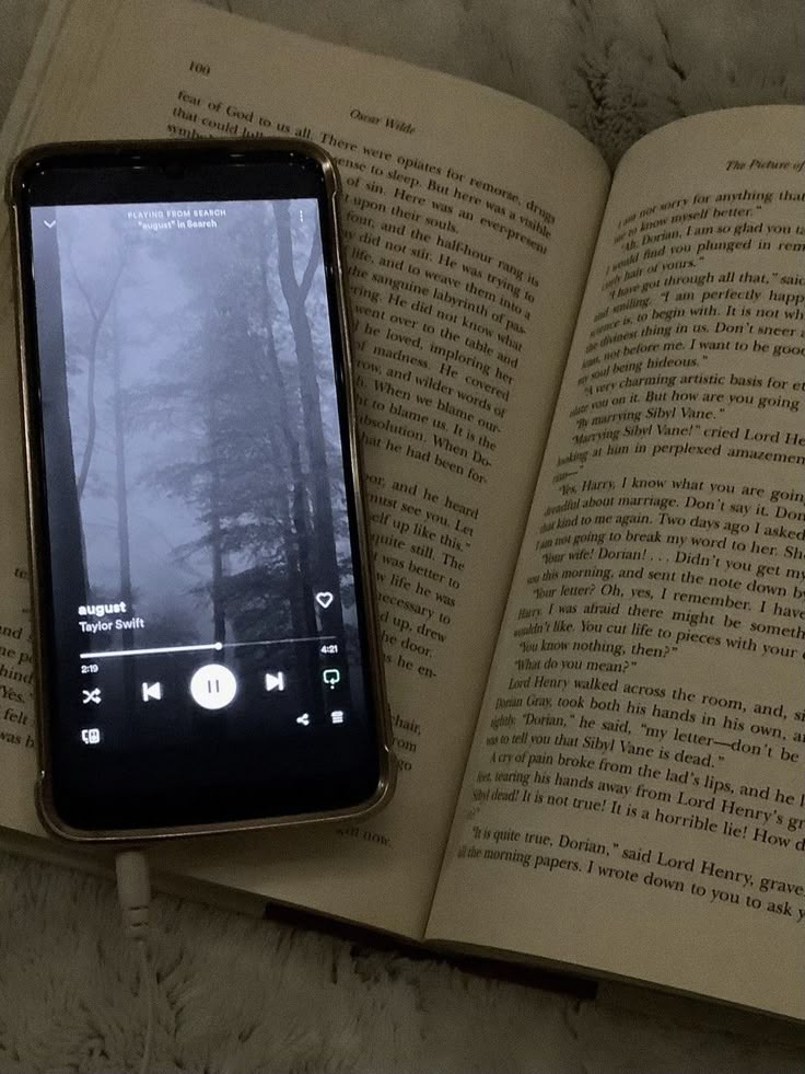 an open book with a cell phone sitting on top of it