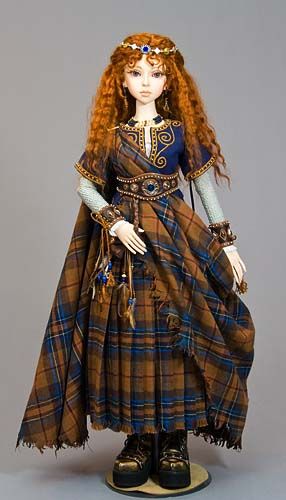 a doll is dressed in plaid and wearing a dress with an elaborate head piece on it