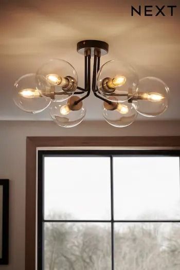 a chandelier hanging from the ceiling in front of a window