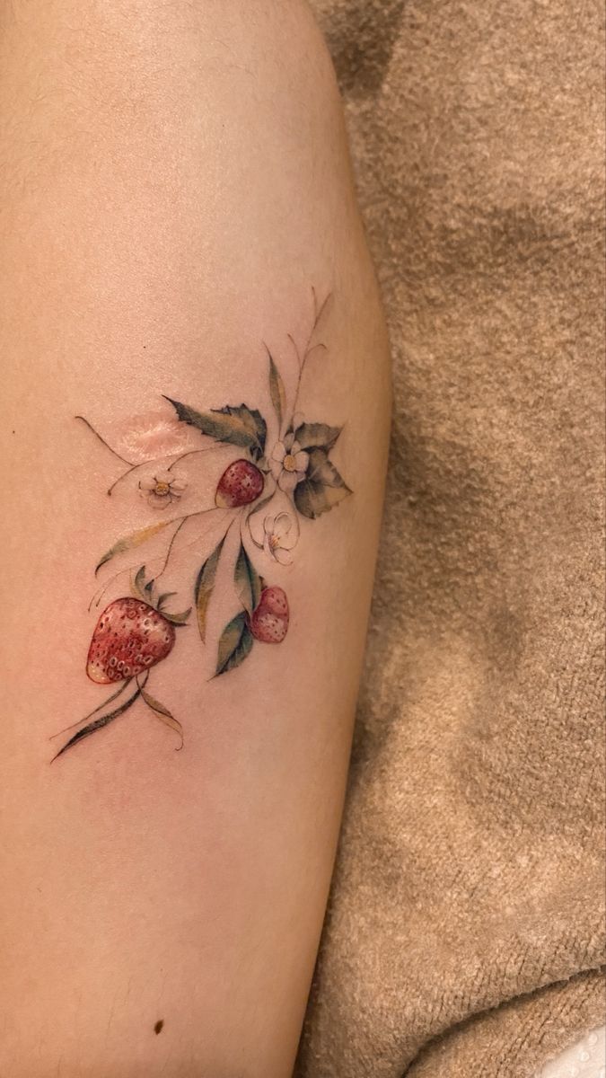 a woman's thigh with flowers and leaves on it