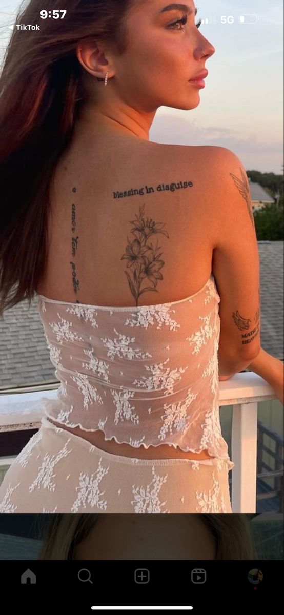 the back of a woman's body with tattoos on her upper arm and shoulder