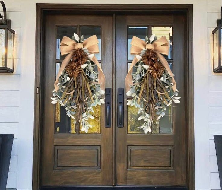 two wreaths on the front door of a house