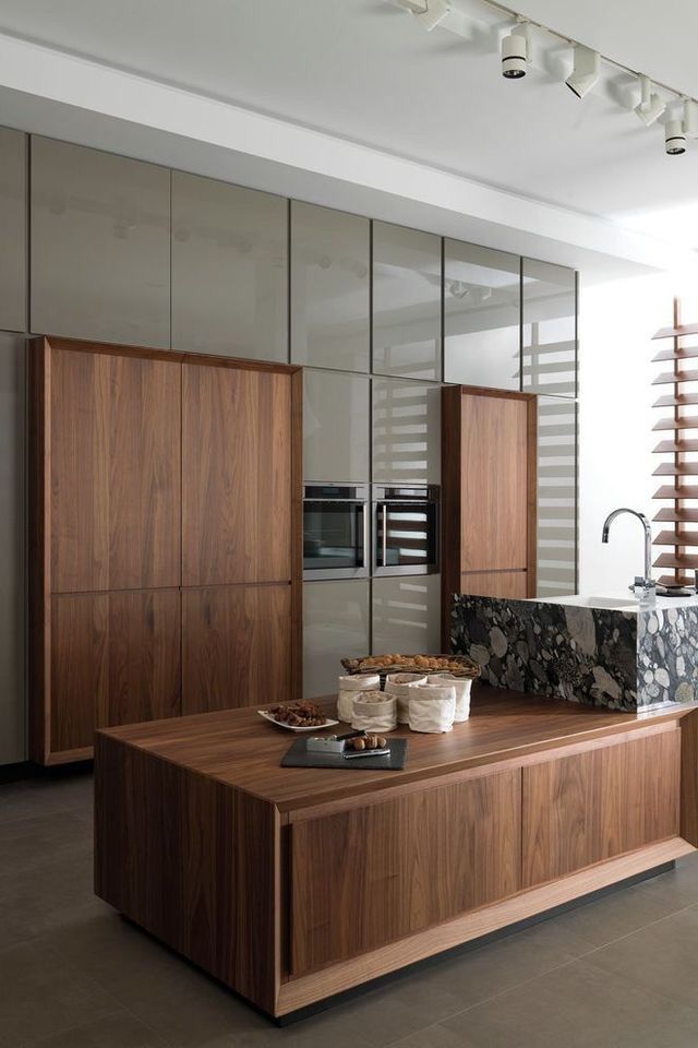 a modern kitchen with wooden cabinets and marble counter tops, along with stainless steel appliances