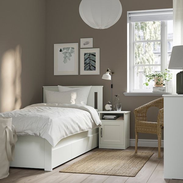 a white bed sitting in a bedroom next to a window