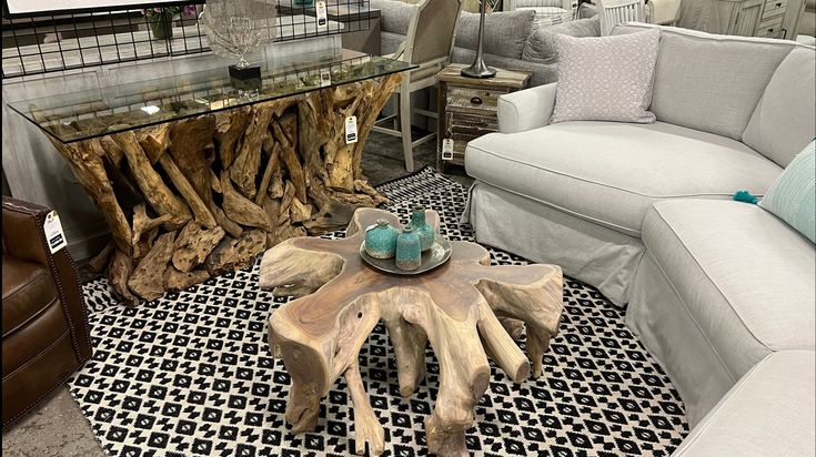 a living room filled with furniture next to a glass top table and white couches