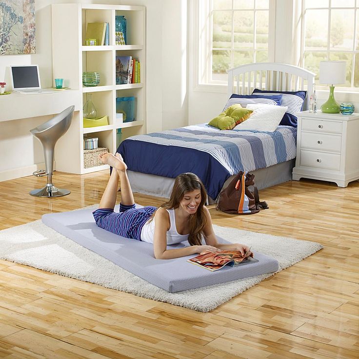 a woman laying on the floor with her feet up and reading a book in front of her