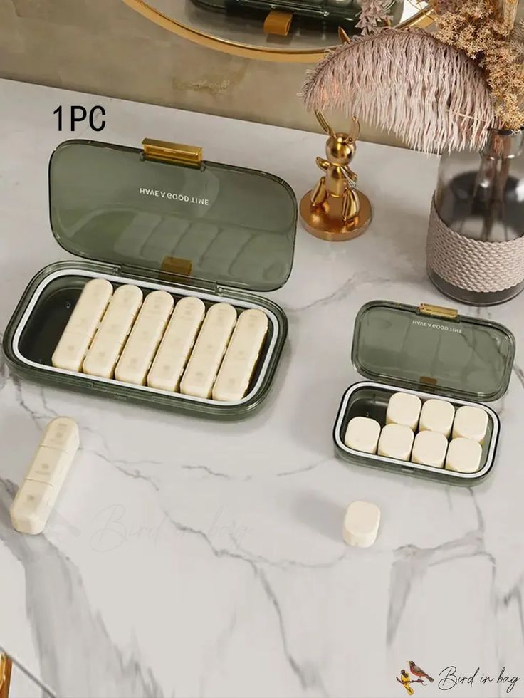 two green and white trays filled with marshmallows on a marble table