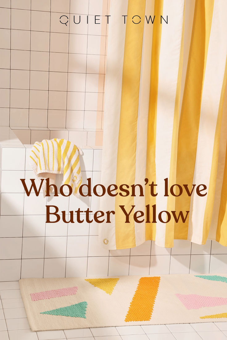 a bathroom with yellow shower curtains and a rug on the floor that says, who doesn't love butter yellow?