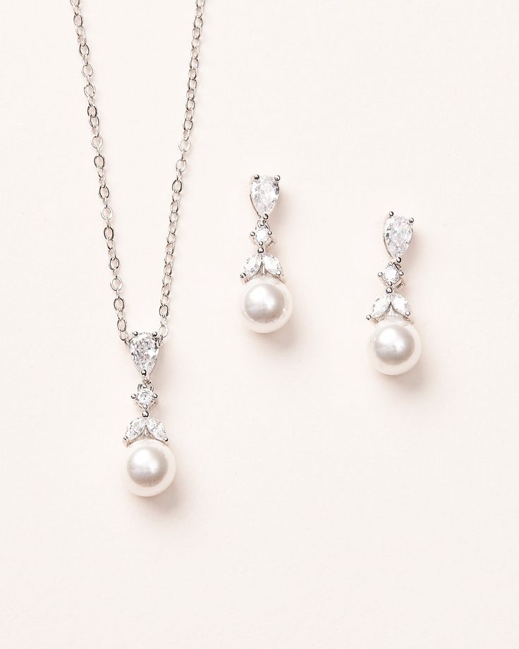 two pieces of jewelry set on a white background, including a necklace and earring