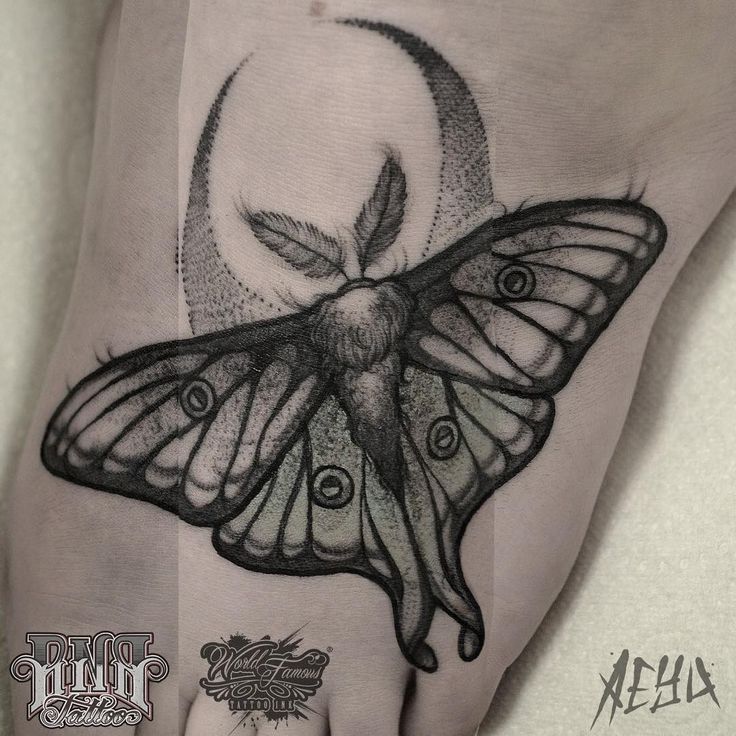 a hand with a butterfly tattoo on it