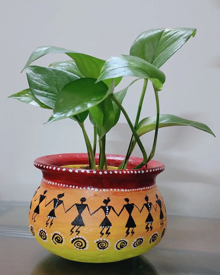 a potted plant with people painted on it