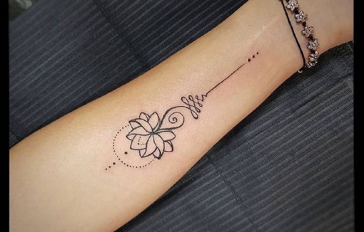 a woman's arm with a small tattoo design on the left side of her arm