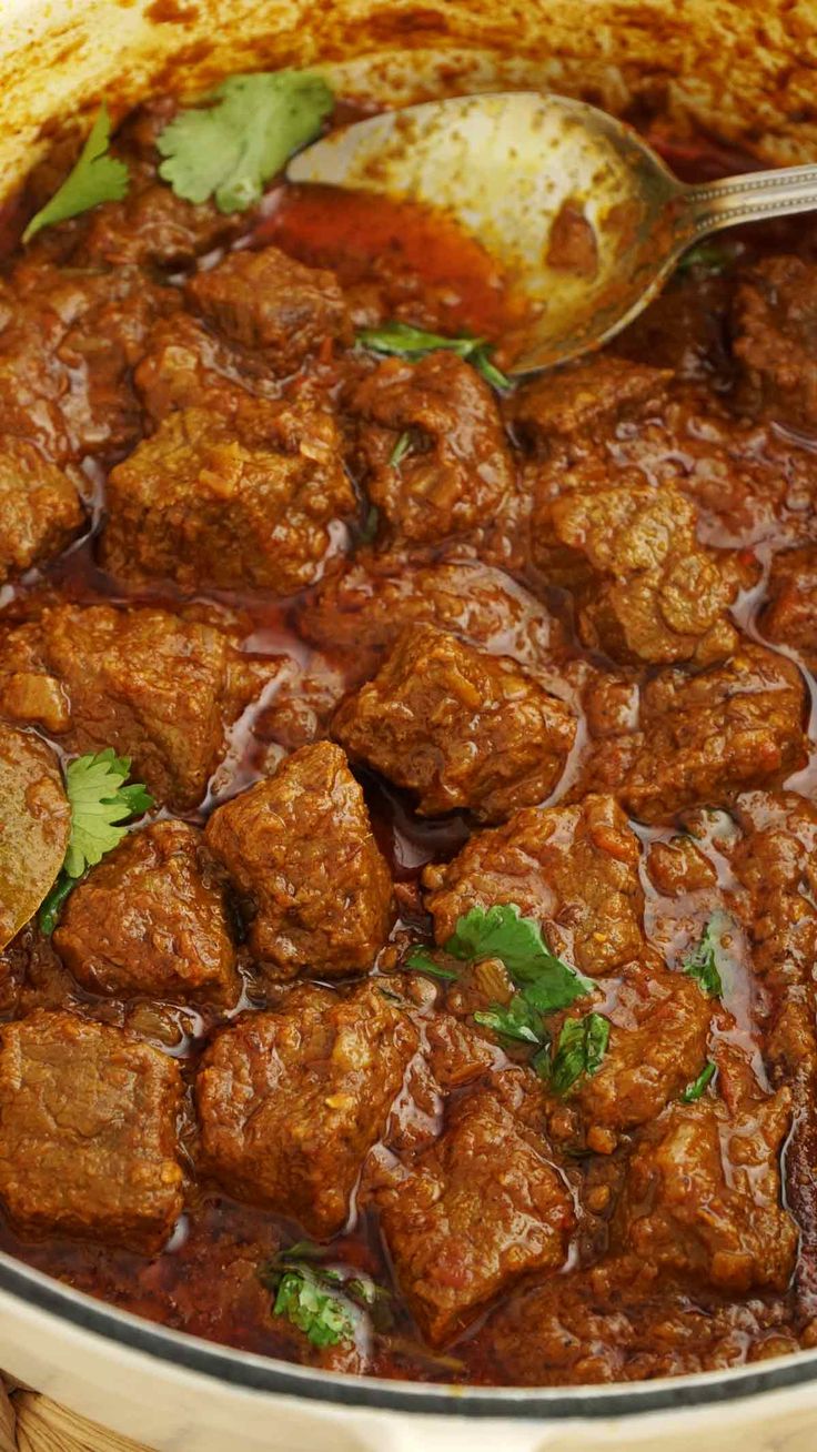 a pot filled with meat and garnished with cilantro