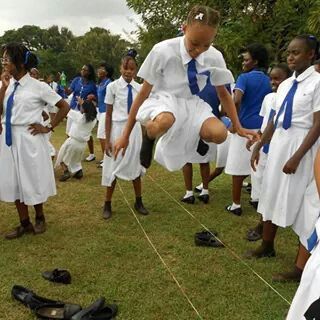 a group of girls in white dresses are performing acrobatic tricks on a rope