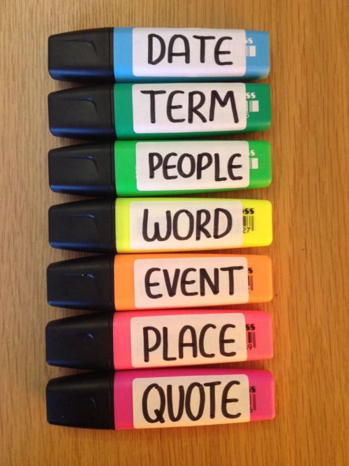 four markers with words written on them sitting next to each other in front of a wooden table