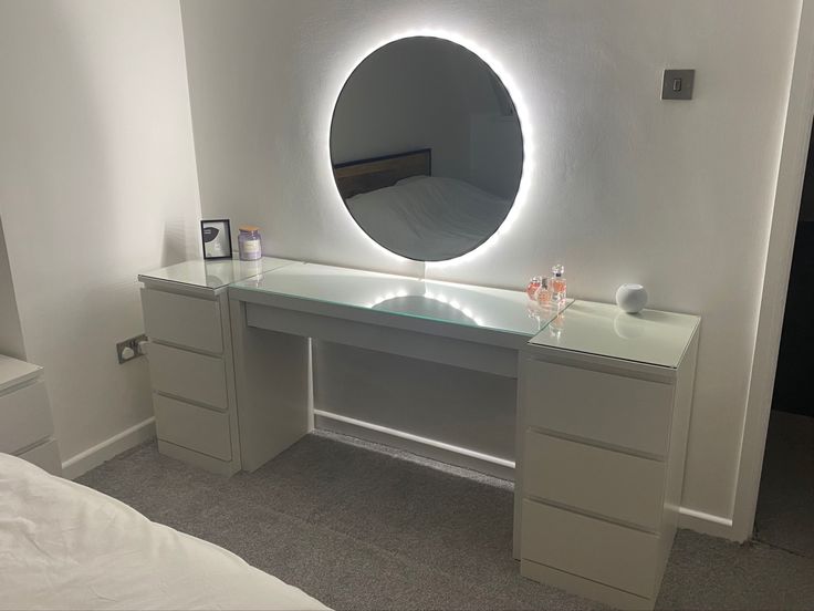 a white desk with a round mirror on it's side and drawers underneath the table