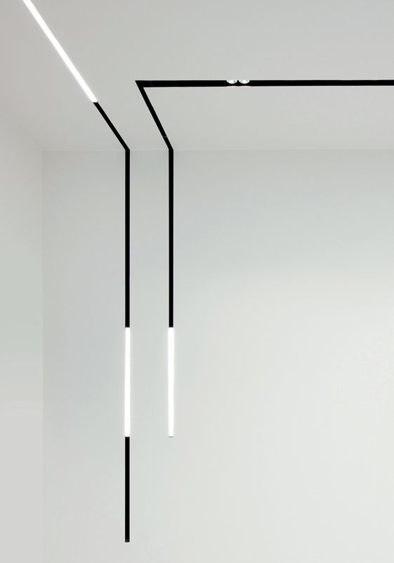 an empty room with black and white lines hanging from the ceiling in front of it