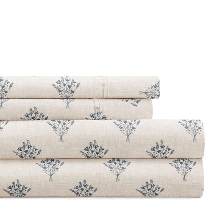 three sheets with blue flowers on them, one in white and the other in grey