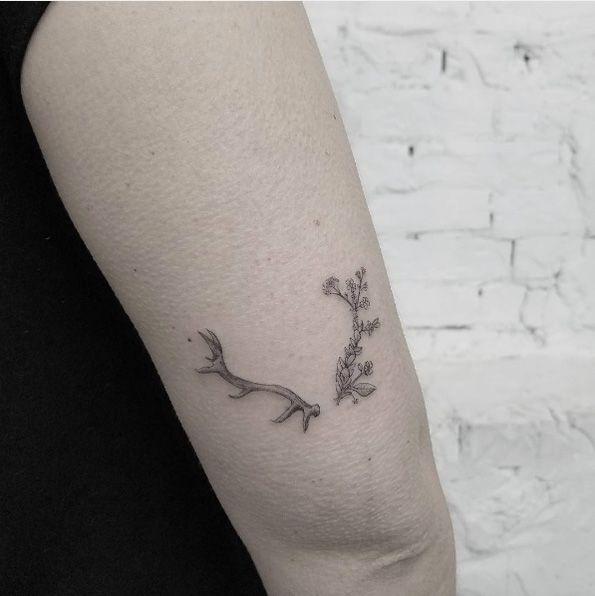 a woman's arm with a small flower tattoo on it