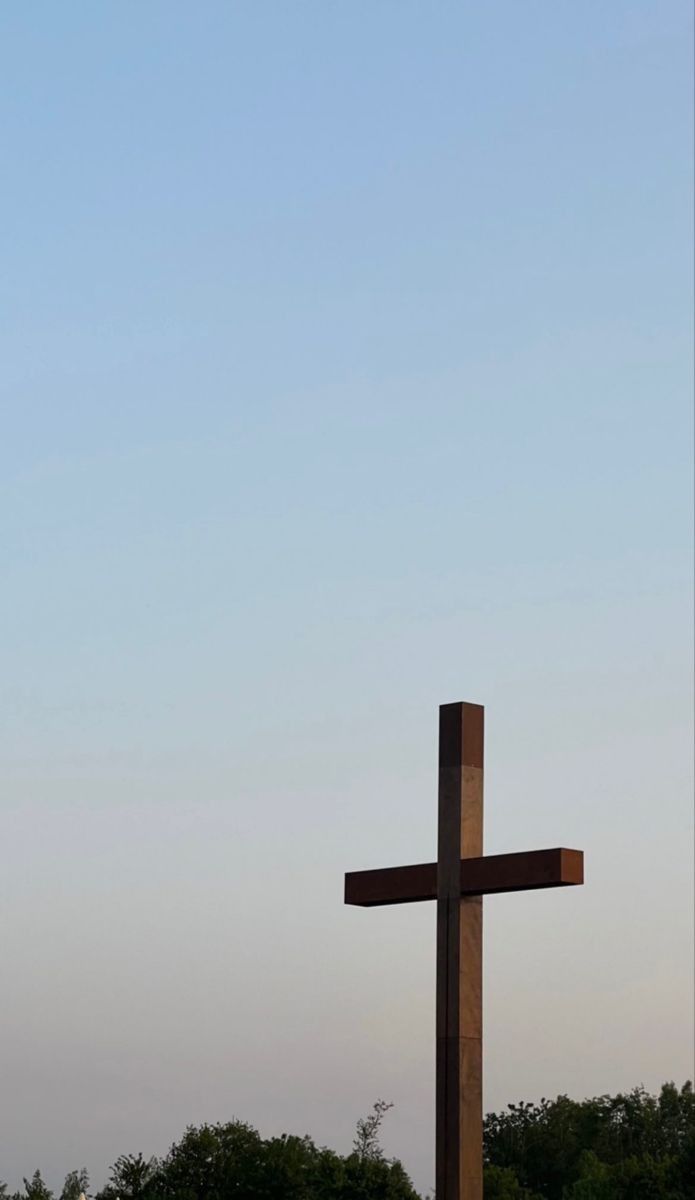 a large wooden cross sitting in the middle of a field