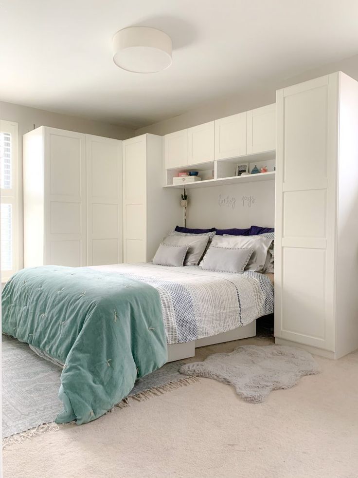 a bedroom with a bed and white cabinets