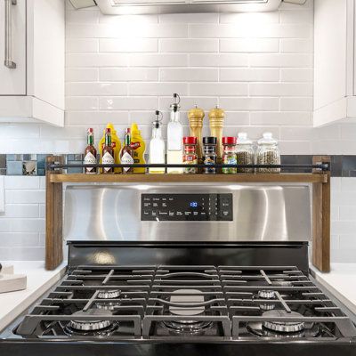 a stove top oven sitting inside of a kitchen next to white cupboards and counter tops