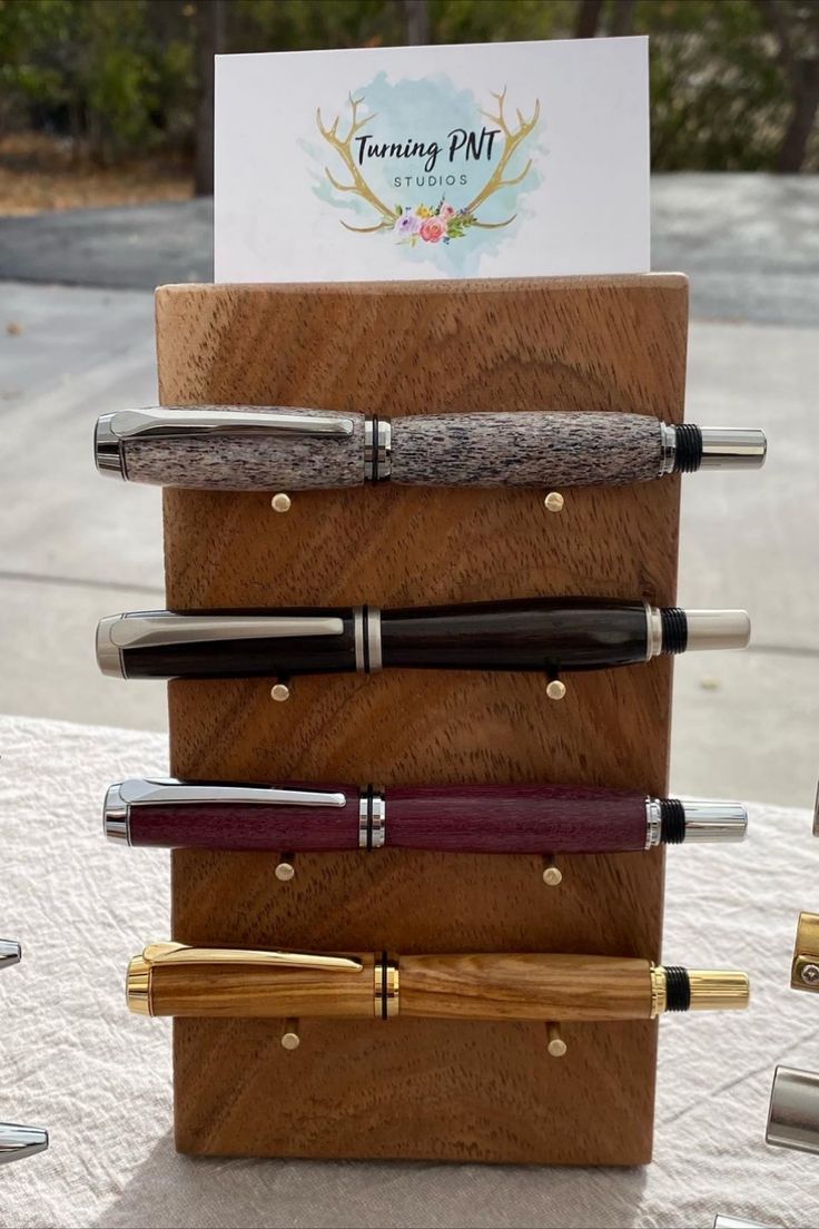 four different types of pens are stacked on top of each other in a wooden holder