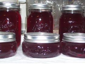 jars filled with red liquid sitting on top of a table