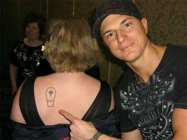 a man with a tattoo on his back pointing at the woman's shoulder that has a light bulb tattooed on it