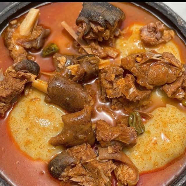 a bowl filled with meat and vegetables on top of a table