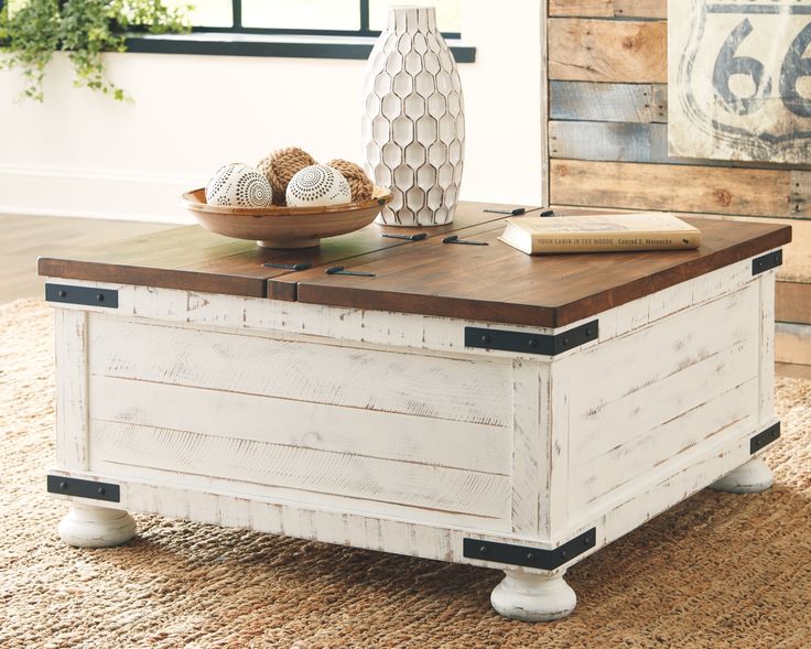 a coffee table with an open trunk on top and a bowl of balls in the middle