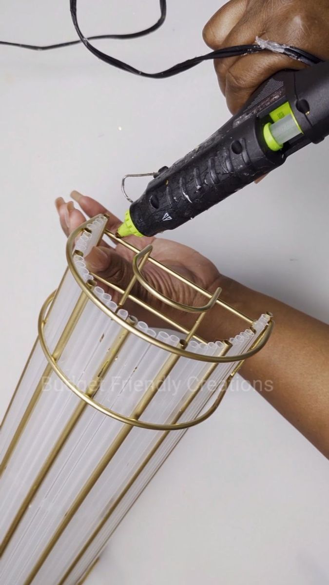 a person using a hair dryer on top of a wire basket with wires attached to it