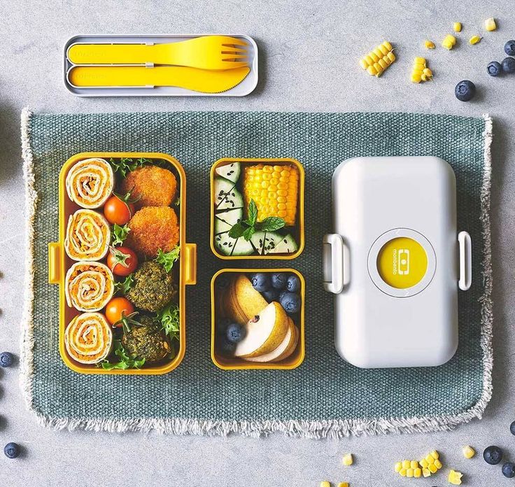 an overhead view of some food in containers with forks and spoons on the side