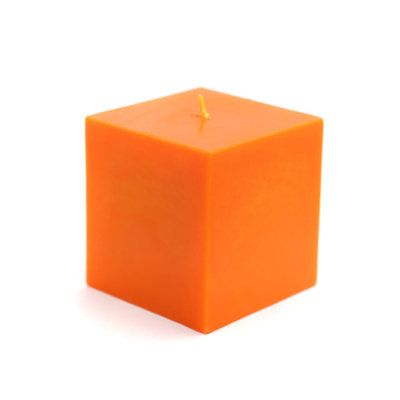 an orange cube with a single candle in it