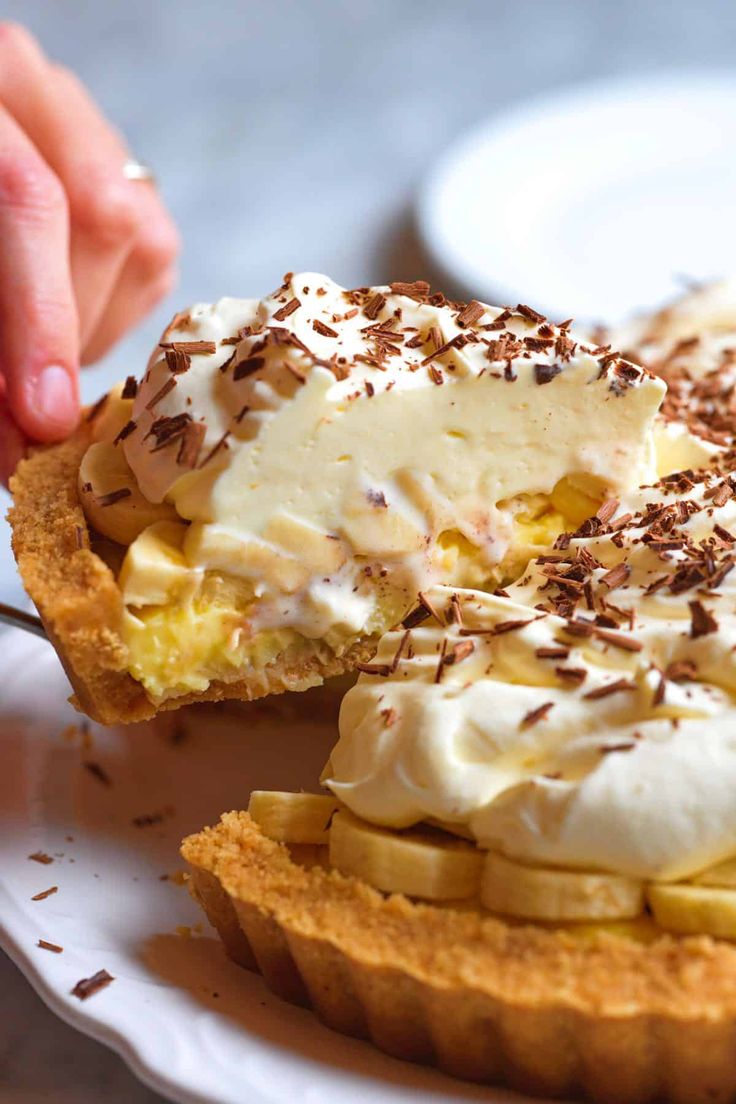 a person cutting into a dessert on top of a white plate