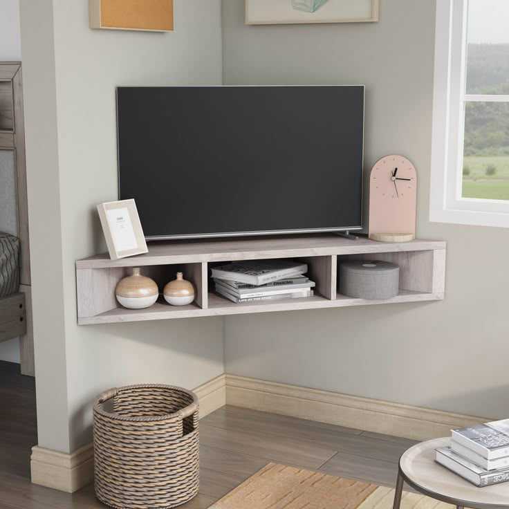 a flat screen tv sitting on top of a wooden shelf