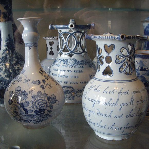 several blue and white vases are on display in a glass case, with writing on them