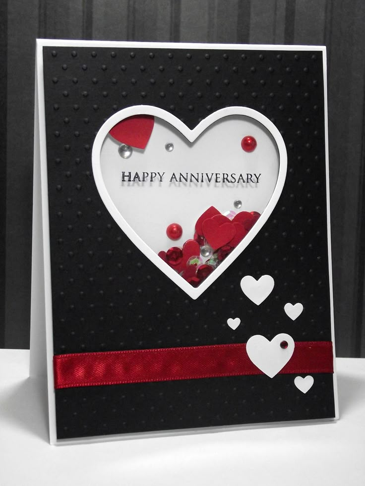 a happy anniversary card with hearts and ribbons on the front, in black and white