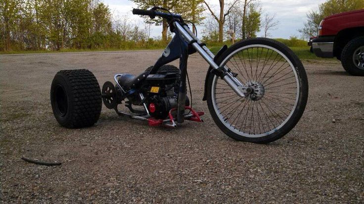 a motorcycle that is sitting on the ground next to a red truck and some trees